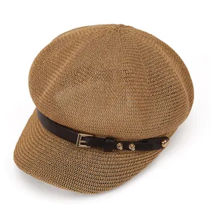 Detailed texture of khaki woven straw baker boy hat with brown leather strap and buckle