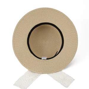 Women's light brown woven straw sun hat featuring elegant white lace ribbon straps