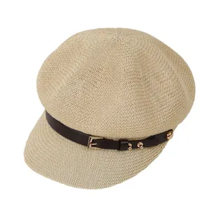 Women's beige woven newsboy cap with brown leather strap and gold buckle detail