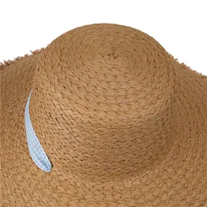 Close-up of woven straw hat texture with blue gingham ribbon and frayed edge