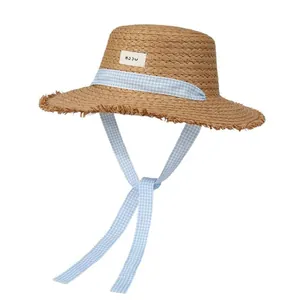 Handwoven straw hat with blue gingham ribbons and raw edge brim for beach sun protection