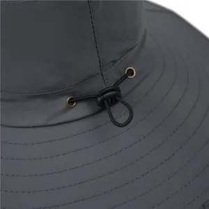 Détail d'un chapeau de soleil gris avec cordon de serrage élastique réglable et boucle