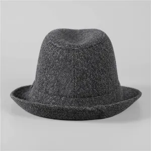 Macro shot of dark grey wool felt fedora showing thick texture and curved top design