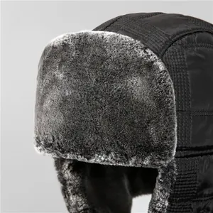 Detailansicht aus gestepptem Nylon und grauem Kunstfellfutter der Wintermütze mit Ohrenklappen