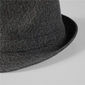 Macro shot of high-quality wool felt texture and stitching on dark grey fedora hat