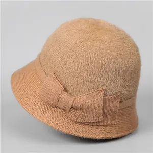 Détail d'un chapeau cloche d'hiver pour femme avec peluche douce et nœud tricoté