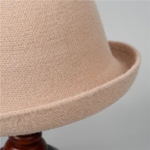 Détail du chapeau cloche en laine beige montrant la texture et le bord arrondi