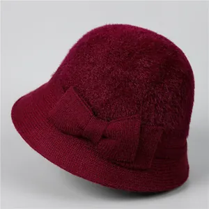 Détail du chapeau cloche en tricot bordeaux avec dessus en peluche et nœud décoratif