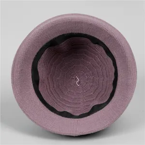 Inside view of a purple knitted cloche hat featuring a black ribbed sweatband and soft texture