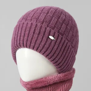 Close-up of purple knit beanie and thick fleece-lined neck warmer with metal tag