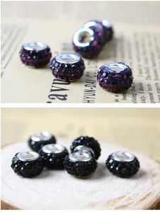 Macro shot of silver plated large hole beads with purple and black rhinestones