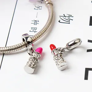 Detailed close-up of lipstick pendants with pink and red enamel and sparkling rhinestones
