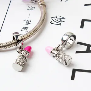 Macro shot of lipstick pendants with pink crystals on a silver snake chain bracelet