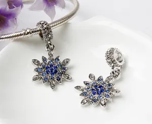 Makroaufnahme von Schneeflocken-Charm mit blauen Zirkonia auf Silber-Schlangenkette