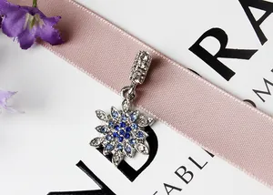 Makroaufnahme von glitzerndem Schneeflocken-Anhänger mit blauen Zirkonia-Steinen
