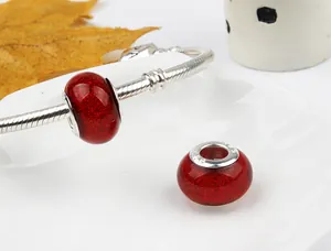 Macro shot of S925 sterling silver stamp on glittery ruby red glass large hole charm bead
