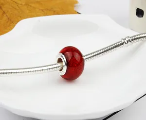 Macro shot of red glitter glass bead with S925 silver core on a snake chain bracelet