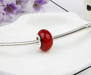 Detailed macro view of a translucent red glitter glass bead with S925 silver core