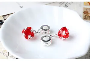 Macro detail of red faceted crystal charms with silver textured metal ring clasps