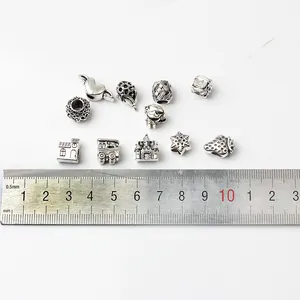 Lot de 48 perles de bijoux DIY en argent vintage avec divers charmes sur fond blanc