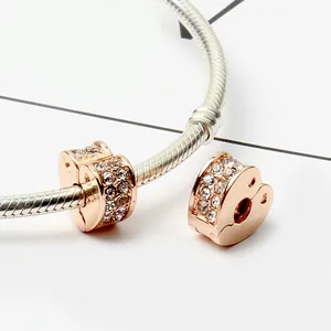 Detail of rose gold heart charm with cubic zirconia on silver snake chain bracelet