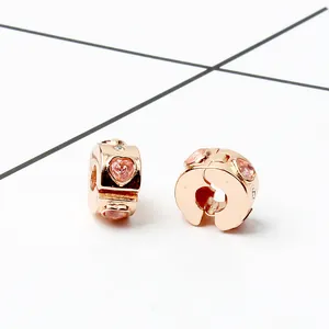 Detail view of rose gold clip charm with pink heart crystal and pave setting stones