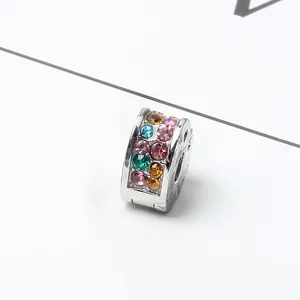 Macro view of cylinder charm bead with multi-colored crystals and silver finish
