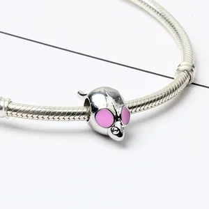 Gros plan d'un charm souris en argent avec émail rose sur un bracelet serpent