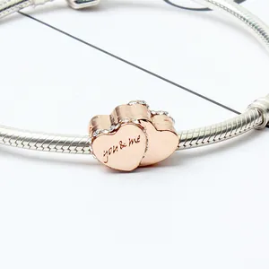 Macro de colgante de corazón en oro rosa con grabado you and me en cadena de plata