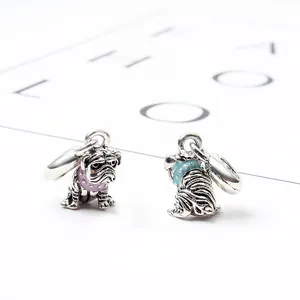Dettaglio macro di ciondoli a forma di carlino in argento con collari in smalto colorato