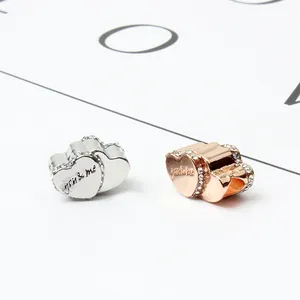 Amuletos de corazón en plata y oro rosa con grabado you and me y piedras circón