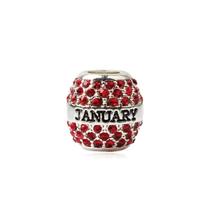 Détail macro du charm de janvier en argent avec zircon rouge et texte gravé