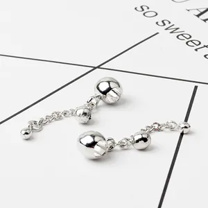 Macro shot of silver sphere pendants with three metal beads on delicate link chains