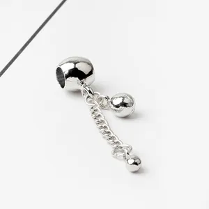 Close-up of silver metal bead slider with hanging ball charms for DIY charm bracelets