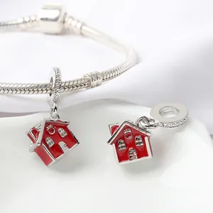 Vue macro du pendentif maison émaillé rouge avec pierres sur bracelet maille serpent argent