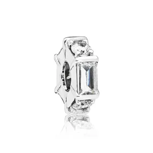 Nahaufnahme eines Silber-Charms mit rechteckigem Kristall und Sonnenstrahl-Metall-Details