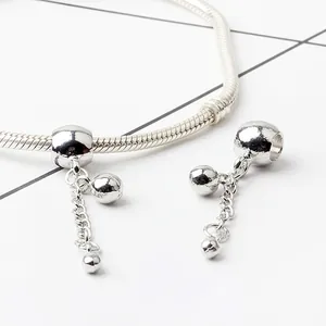 Macro shot of silver ball charm pendants on a snake chain for DIY jewelry making