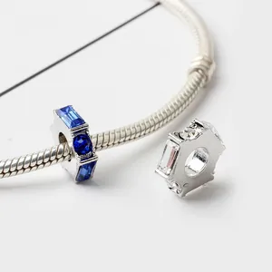 Detailansicht silberner Hexagon-Charms mit blau-weißen Kristallen auf Schlangenkette