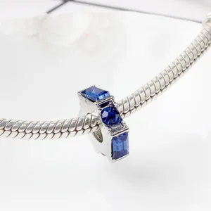 Makroaufnahme von Silber-Charm mit drei blauen Kristallen an einer Schlangenkette