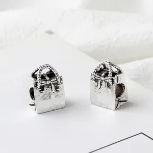 Macro shot of retro silver handbag-shaped alloy bead with detailed bow for DIY jewelry making