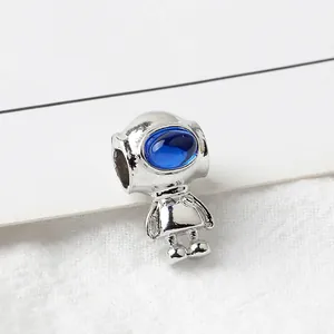 Macro detail of silver astronaut bead with blue crystal visor for DIY jewelry making