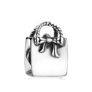 Polished S925 sterling silver handbag charm with bow detail and twisted handle for jewelry