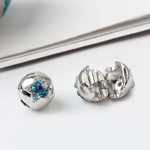 Dettaglio macro di charms a stella in argento con cristalli blu e chiusura a clip