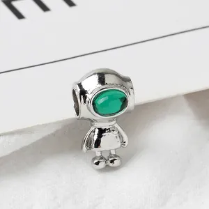 Macro view of silver astronaut charm with green glass visor for DIY jewelry making