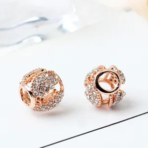 Macro shot of rose gold openwork beads with white rhinestones for DIY jewelry