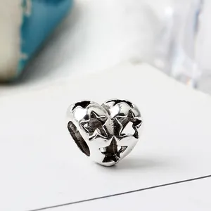 Charm cuore in argento ossidato con intricati motivi a stella traforati ed eleganti
