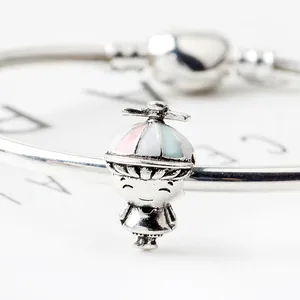 Macro shot of silver boy charm with colorful propeller hat on a minimalist bracelet