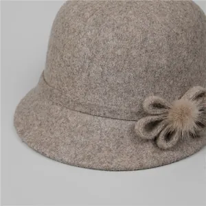 Détail d'un chapeau cloche en laine avec nœud texturé et décoration pompon doux