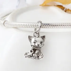 Makroaufnahme von Vintage Silber Katzenanhänger mit Herzanhänger an Schlangenarmband