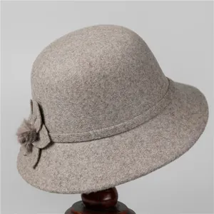 Detail of wool cloche hat for elderly women featuring felt flower and faux fur pompom